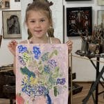 O fetiță ține în brațe un tablou cu flori, pictat de ea, într-un atelier de creație la Muzeul de Artă Constanța