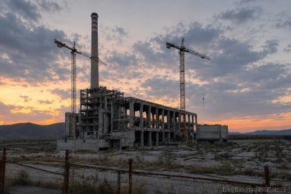Ilustrație generată cu AI: o centrală pe cărbune abandonată, în construcție neterminată, la apus